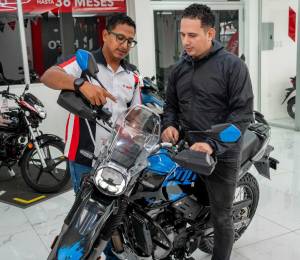 Vendedor de tienda Hero en Guayaquil muestra varias características de una motocicleta