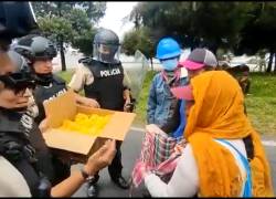 Policías y manifestantes intercambian alimentos en medio de protesta pacífica.