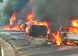 Fotografía que muestra a vehículos incendiándose tras el volcamiento del camión de carga.