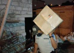 Agentes de la fuerza pública sacan las cajas de cartón en las que se había metido la droga.