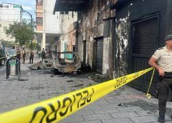 Fotografía que muestra el vehículo incinerado, al costado de una salsoteca, en el centro de Guayaquil.
