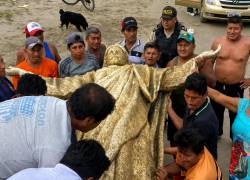 Fotografía que muestra a moradores sosteniendo la figura de Cristo.