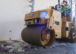 Una máquina aplanadora pasa por encima de decenas de botellas de plástico para iniciar el proceso de reciclado, el 22 de julio de 2022, en Galápagos (Ecuador).