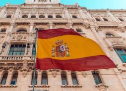 Bandera de España flameante delante de un edificio de Madrid.
