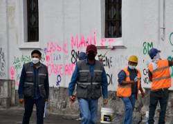 Una cuadrilla recupera una pared del centro histórico de Quito.