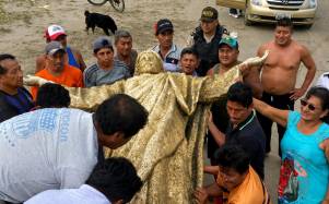 Fotografía que muestra a moradores sosteniendo la figura de Cristo.