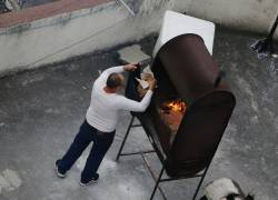 Un hombre quema documetos en el techo de la sede diplomática, la tarde de este miércoles.