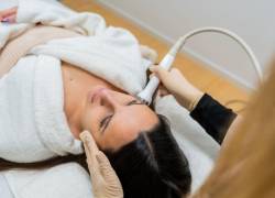 Mujer durante tratamiento estético facial en cabina.