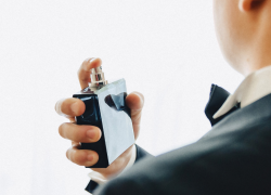 Imagen referencial de un hombre colocándose perfume. (Foto: Freepik.)