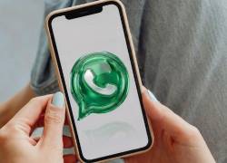 Composición de imagen de una persona con un celular y el icono de WhatsApp modificado.