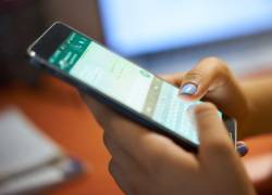 Mujer usando la aplicación de mensajería instantánea WhatsApp.