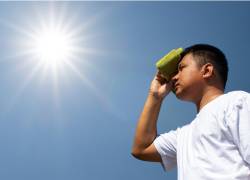 Persona cubriendose del intenso sol con una toalla.