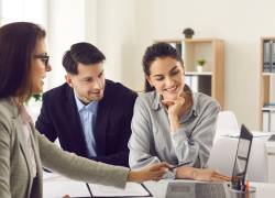 Pareja revisa con experta su buró crediticio para la solicitud de un crédito.