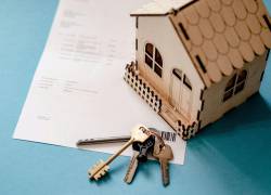 Casa modelo con llaves y documento.