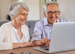 Adultos mayores utilizando un computador portátil.