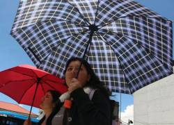 Quiteños se protejan con parasoles de las altas temperaturas durante el día, que se registran en la ciudad capital.