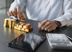 Hombre calculando lingotes de oro.