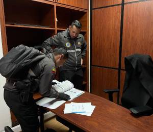 Fotografía que muestra a agentes investigativos de la Policía Nacional en dependencias del Municipio de Quito.