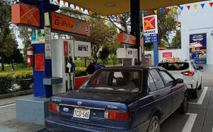 Fotografía refecnial que muestra a varios autos en una estación de servicio.
