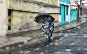 Fotografía de una mujer bajo la lluvia en Quito.