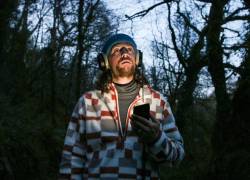 El ornitólogo irlandés Sean Ronayne graba los cantos de los pájaros, y más precisamente el coro del amanecer, en el bosque de Glenbower, cerca de Cobh, en las afueras de Cork, en el sur de Irlanda, el 3 de abril de 2025.