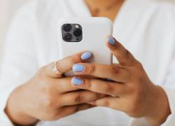 Mujer navegando en su dispositivo móvil iPhone.