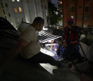 Integrantes del Cuerpo de Bomberos rescatan a una persona este miércoles, en Caracas.