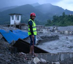 Un miembro de los equipos de rescate observa el lugar donde se encuentran edificios dañados tras las inundaciones repentinas en Trishuli Bazar, en el distrito nepalí de Nuwakot, el 29 de agosto de 2026.