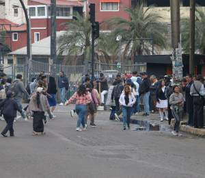 Ciudadanos esperan cerca de paradas de buses, en medio de la restricción de la circulación de unidades.