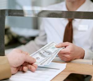Una persona recibe dinero en una institución financiera.