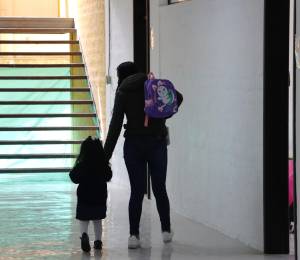 Fotografía referencial de una madre de familia tomando de la mano a su hija.
