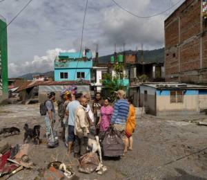 Un grupo de sobrevivientes de las inundaciones observan los daños registrados en sus hogares.