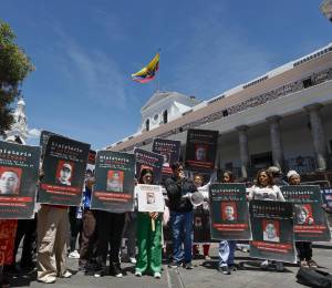 Familiares de personas desaparecidas sostienen carteles durante un plantón en el Palacio de Carondelet.