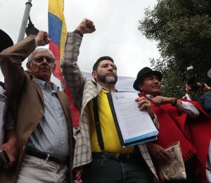Fotografía que muestra al abogado Washington Andrade (2-I) y al dirigente indígena Leonidas Iza (3-I) frente a la sede del Consejo Nacional Electoral (CNE).