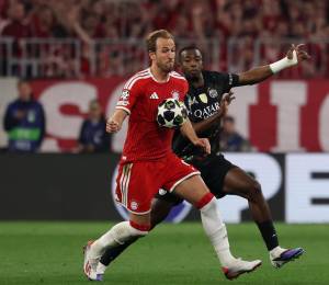 Harry Kane y Willian Pacho disputando el balón durante un partido de Champions League entre el Bayern Múnich y el Paris Saint-Germain.