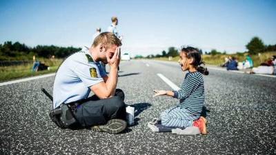 Las conmovedoras fotos de un polic&iacute;a jugando con una refugiada