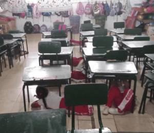 Imagen que muestra a estudiantes agachados bajo sus mesas durante el ataque armado.