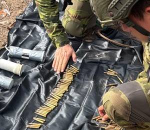 Fotografía que muestra a militares revisando artillería pesada en el campamento.