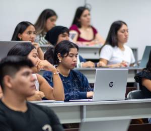 Un grupo diverso de estudiantes escucha atentamente durante una clase universitaria.