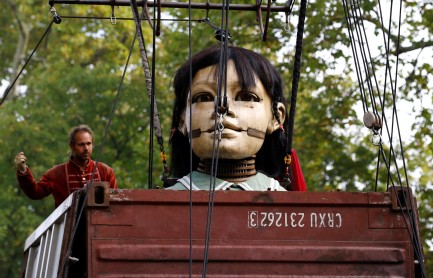 Títere gigante de una niña se mueve por las calles de Ginebra