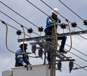Imagen referencial que muestra a trabajadores de la Empresa Eléctrica de Quito (EEQ) arreglando un cable tensor.