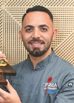 El chef Daniele Gagliotta posa en con una de sus elabradas pizzas, que proponen salirse de lo convencional.