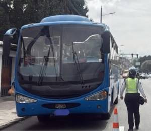 En la imagen, un agente de tránsito supervisa el transporte público.