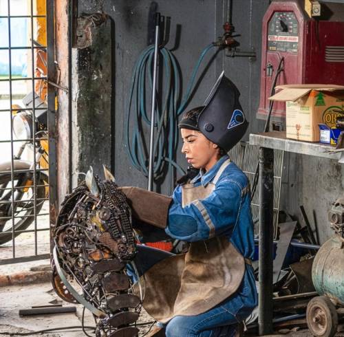 Rudy creando una de sus piezas en un taller automotriz del sur de Guayaquil.