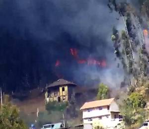 Captura de video del ECU 911 que muestra llamas a tan solo metros de viviendas en el cerro Abuga.