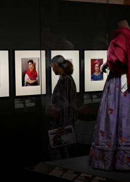 Un visitante mira los retratos fotográficos de la fallecida artista mexicana Frida Kahlo junto a los atuendos que le pertenecieron, durante una vista previa de la exposición Frida Kahlo, más allá de las apariencias en el Palais Galleria de París. (Photo by Emmanuel DUNAND / AFP)