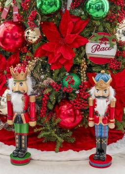 Pie de árbol navideño decorado con cascanueces, esferas grandes y ornamentos variados.