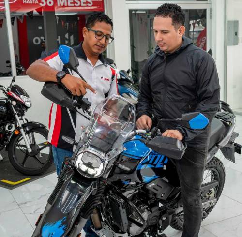 Vendedor de tienda Hero en Guayaquil muestra varias características de una motocicleta
