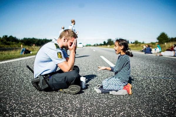 Las conmovedoras fotos de un policía jugando con una refugiada