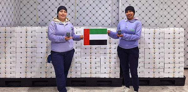 $!Trabajadoras de Nobis Fruit Company muestran bandera de Dubái y arándanos para su exportación.